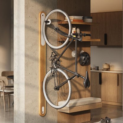 Image of studio apartment with Wallride bike hanger product in white oak and matte white, hanging on the wall. a black and white bike is hanging on the Wallride hanger.