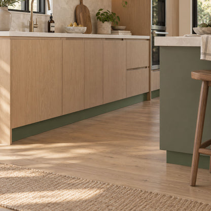 Well Well Toe Kick in a minimalist kitchen with oak cabinetry and a recessed green base for streamlined organization